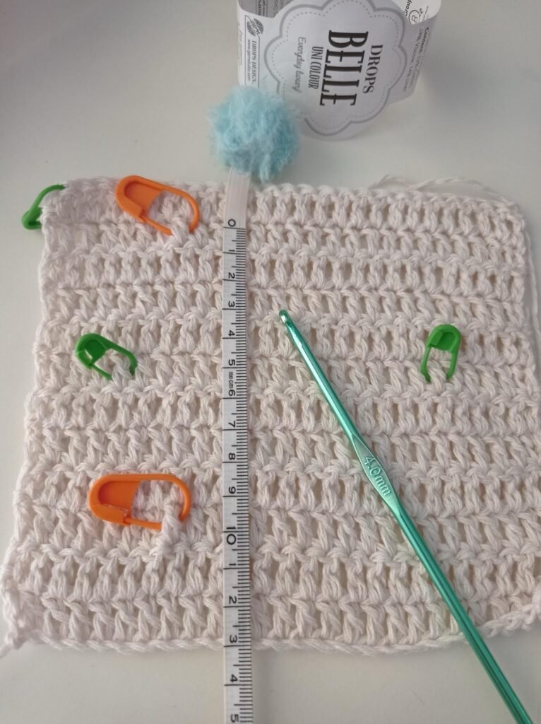 Muestra de tensión de crochet con marcadores y aguja para medir 10 x 10 cm